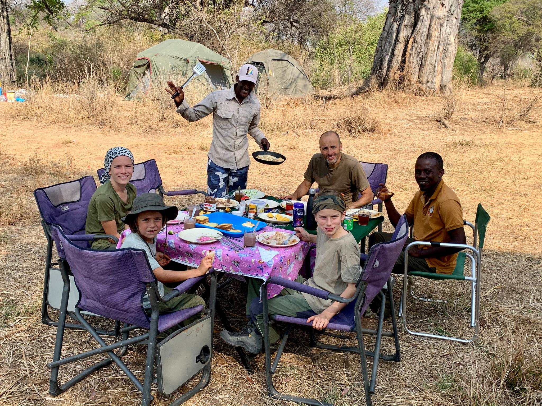 A family gathered around a table, enjoying a delicious spread of food and sharing good times together.