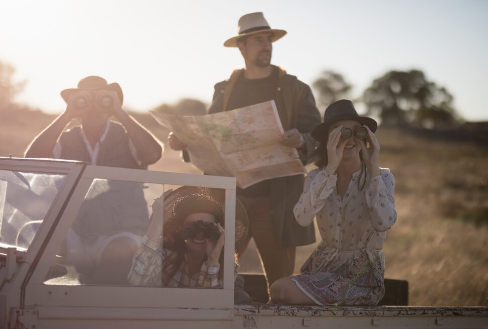 Friends enjoying in vehicle during safari vacation on a sunny day